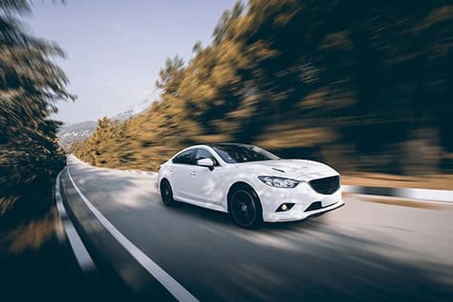 White sport car on a rod in the forest