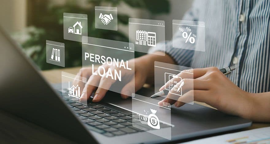 Person typing on a laptop with floating financial icons and the text 'PERSONAL LOAN' above the keyboard. Icons include a house, handshake, calendar, percentage sign, bar chart, and money bag