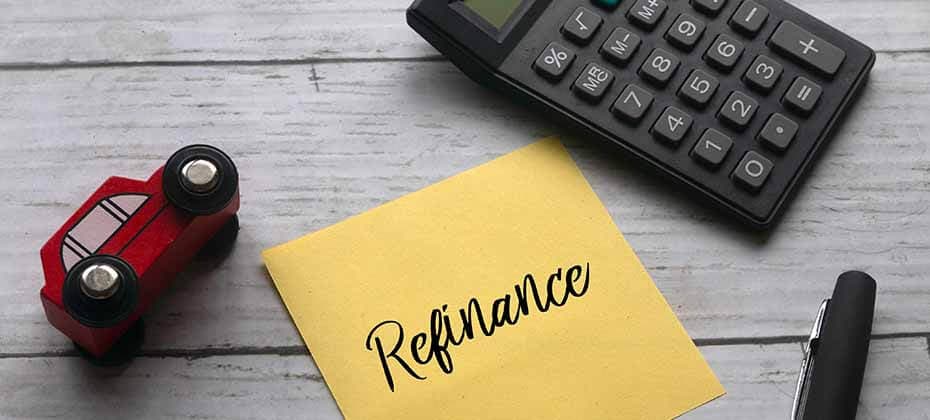 Calculator toy car and sticky note with Refinance written on it showing how to refinance a personal loan for better terms