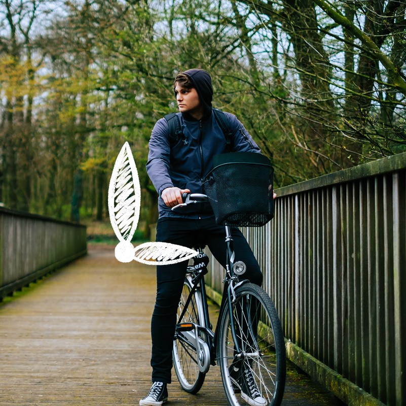 Young man standing with his bike on a bridge