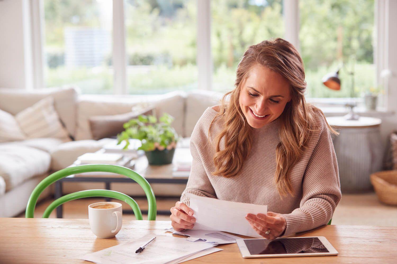 Lady sitting at table with papers and iPad