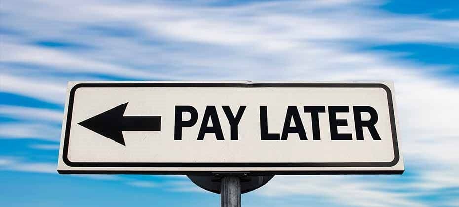 Pay Later road sign with arrow against blue sky representing buy now pay later BNPL and flexible payment options