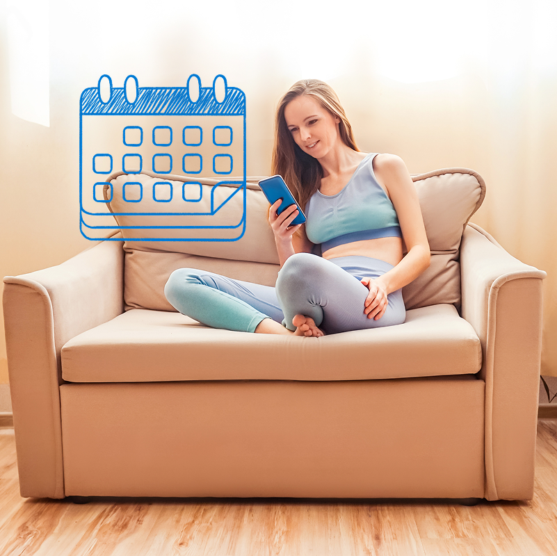 Young woman sitting on the coach and checking her mobile