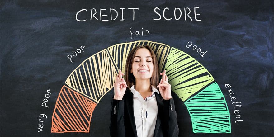 Young woman keeping her fingers crossed for luck. In background credit score measure