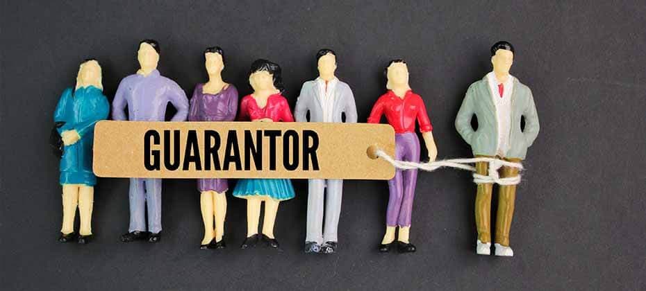 Group of toy figures with one tied to a tag labeled Guarantor explaining how a guarantor helps secure a personal loan