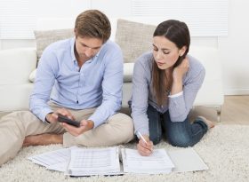 Couple calculating expenses in living room