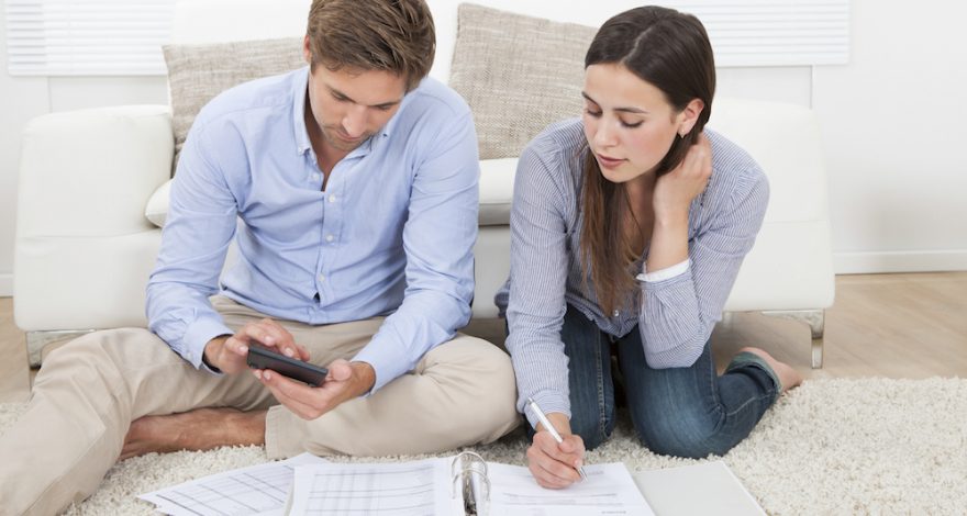 Couple calculating expenses in living room