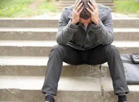 Man stressed with both hands on head