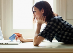 Women lying on the floor with credit card with a laptop