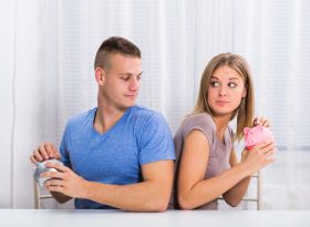 Couple holding piggy bank side by side