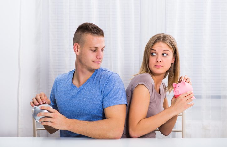 Couple holding piggy bank side by side