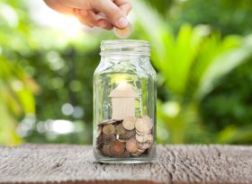 Hand dropping loose change into jar