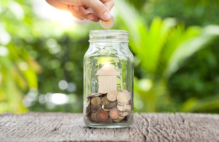 Hand dropping loose change into jar