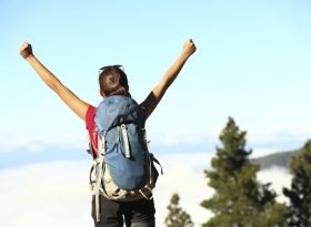 Female hiker with hands in the air