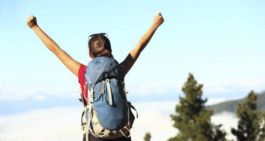 Female hiker with hands in the air