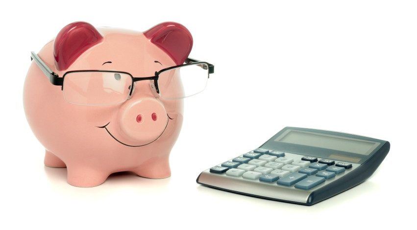 Piggy bank with calculator on the table