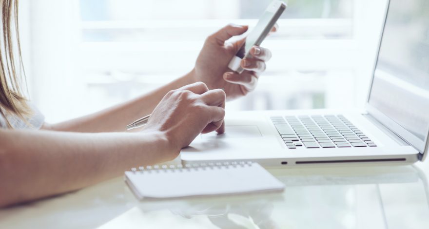 Woman calculating expenses on the mobile phone