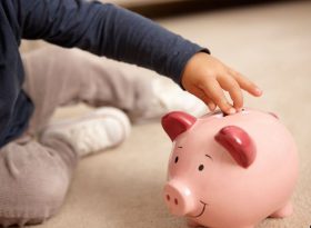 Children putting money into piggy bank