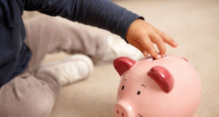 Children putting money into piggy bank